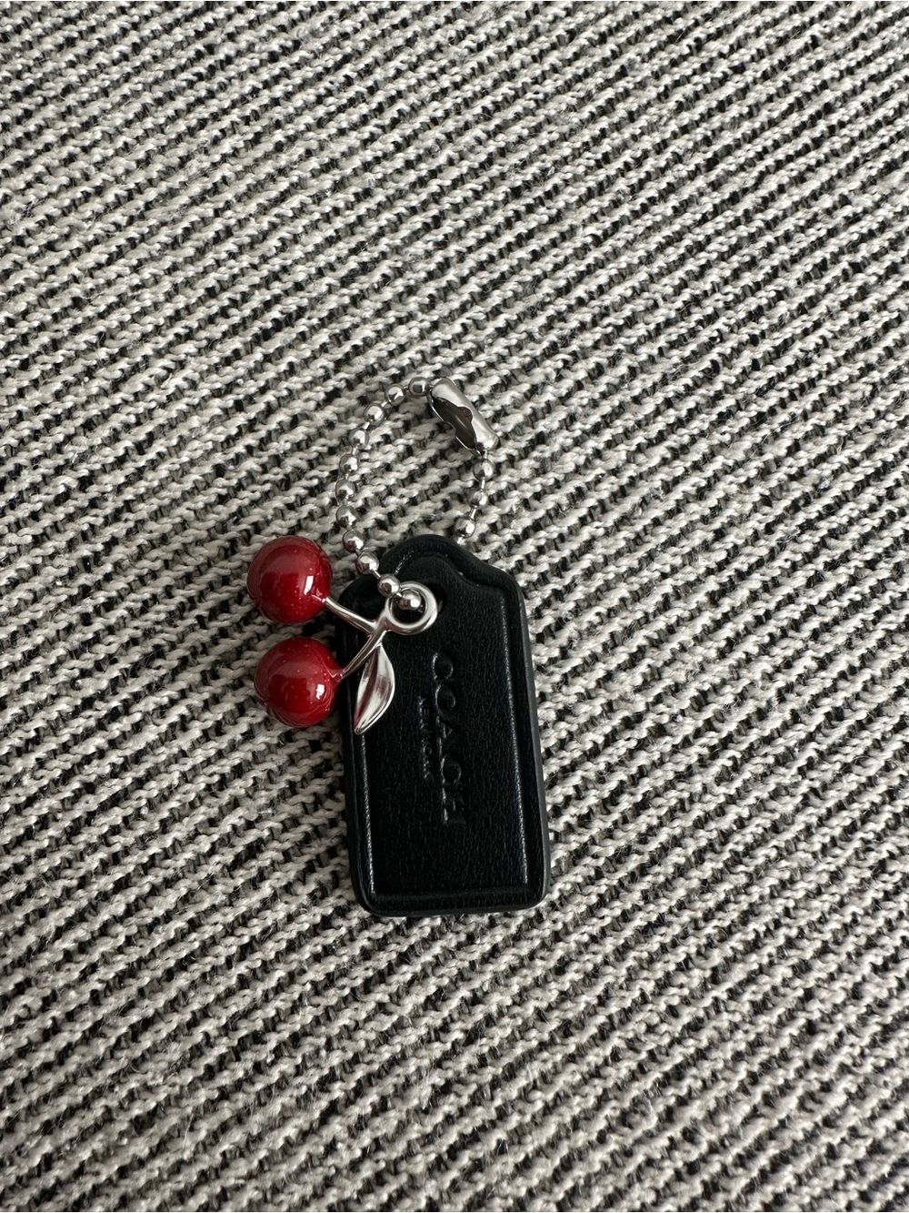 Coach leather hang tag with cherry bag charm
